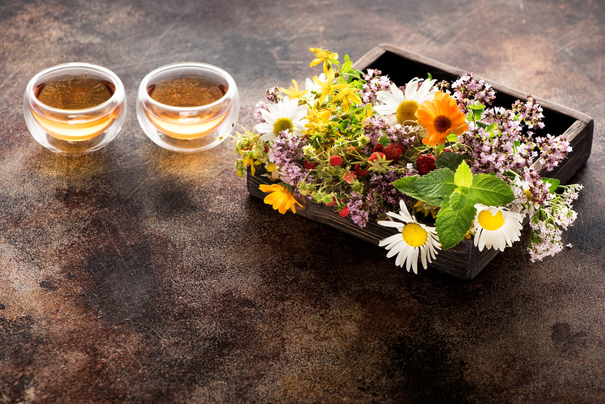 Herbs and flowers for herbal healing tea in a wooden box and cups tea